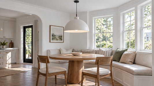 White dome pendant centered above a round oak table in a daylight breakfast nook.